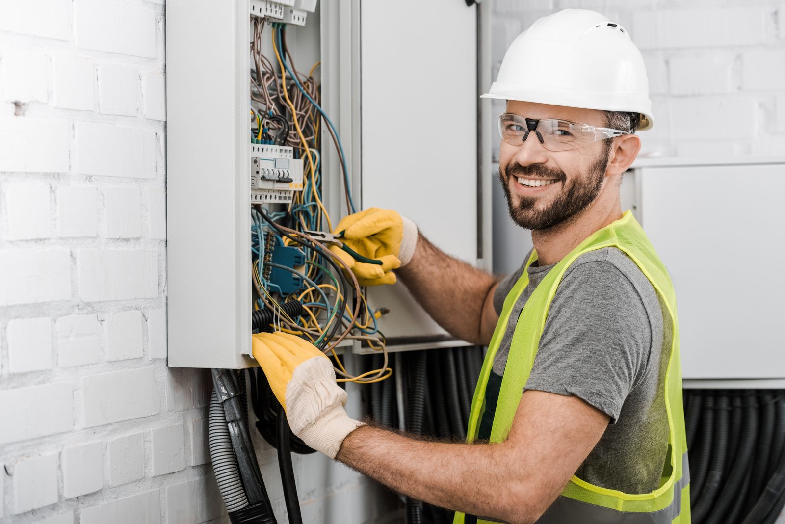 Smiling electrician working at an electrical panel