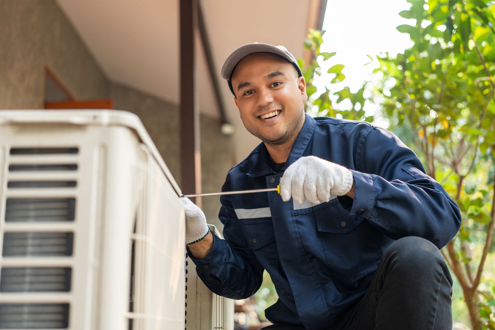 HVAC technician cleaning an outdoor mini-split unit