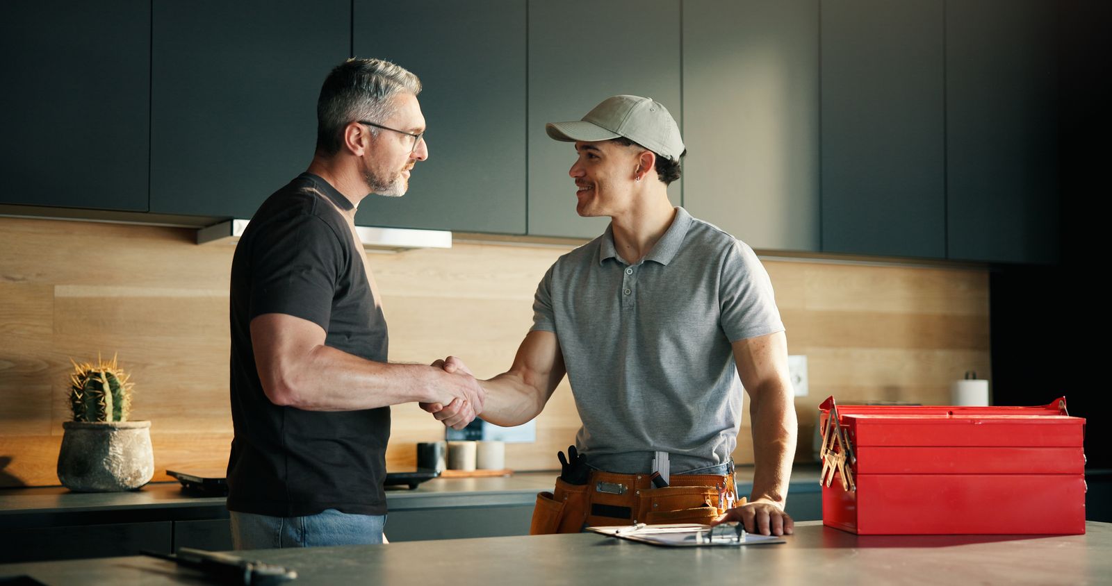 Plumber shaking hands with a homeowner in the kitchen